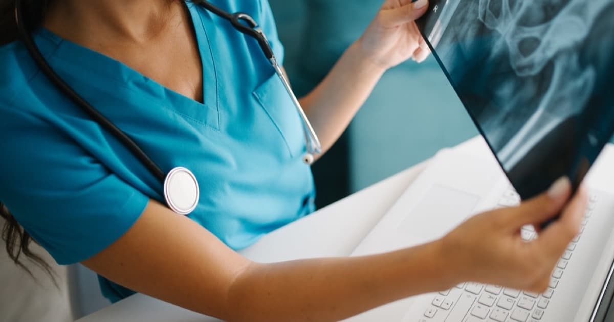 Healthcare professional reviews X-ray images while working at a clinical office, featured image for Señales de autoridad de marca para salud y servicios profesionales en Paraguay