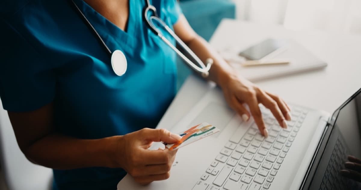 Healthcare professional processing a payment while working on a laptop in a clinic, featured image for Clear Strategy para salud y servicios profesionales: marco en inglés, español y portugués