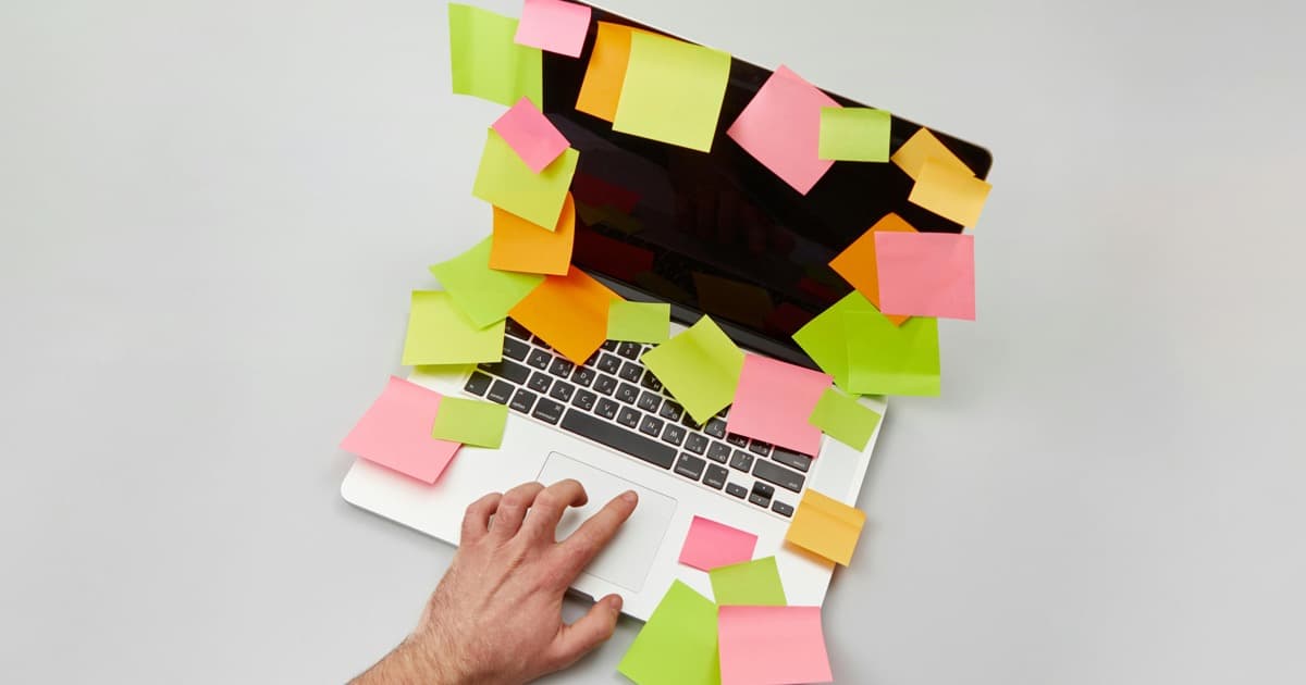Person Holding a Laptop with Sticky Notes, featured image for Cómo las empresas de software en Paraguay pueden explicar productos de IA sin sonar genéricas