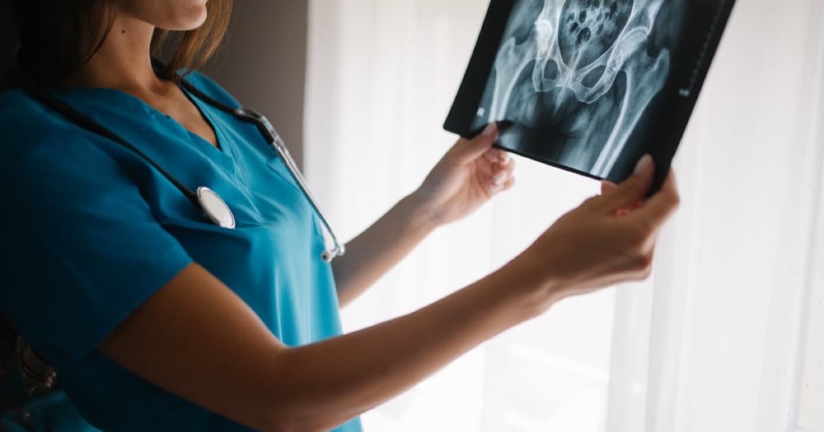 Medical professional reviewing an x-ray in a bright clinical environment, featured image for GEO responsable para clínicas y proveedores de servicios expertos